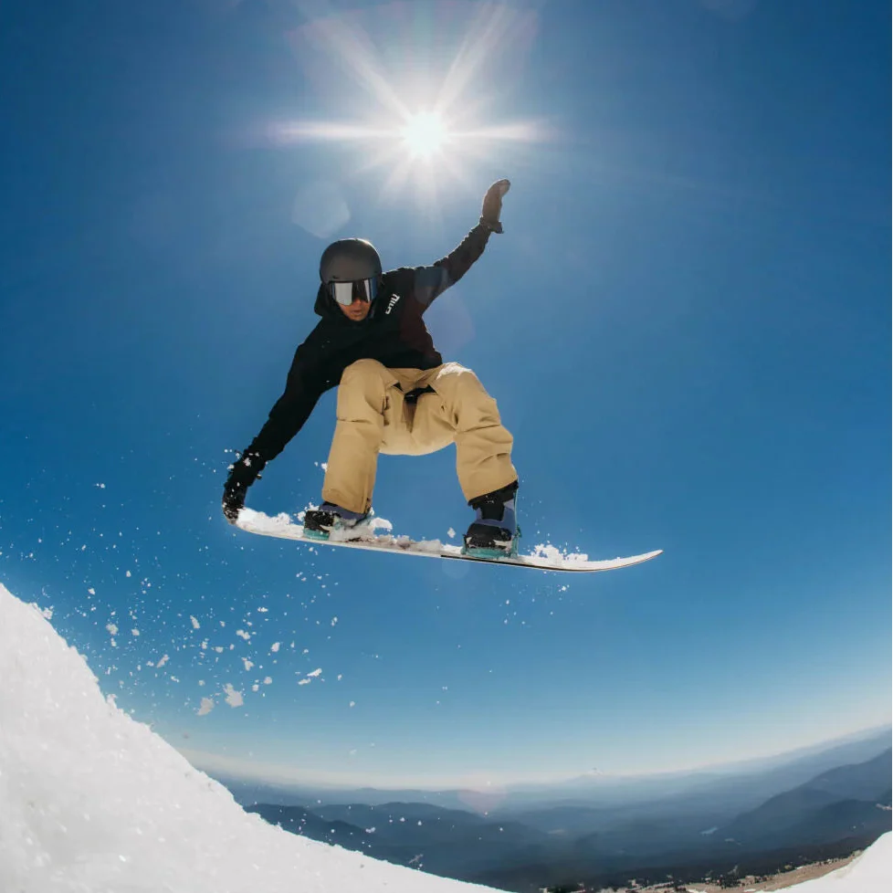 Snowboarder backlit jump
