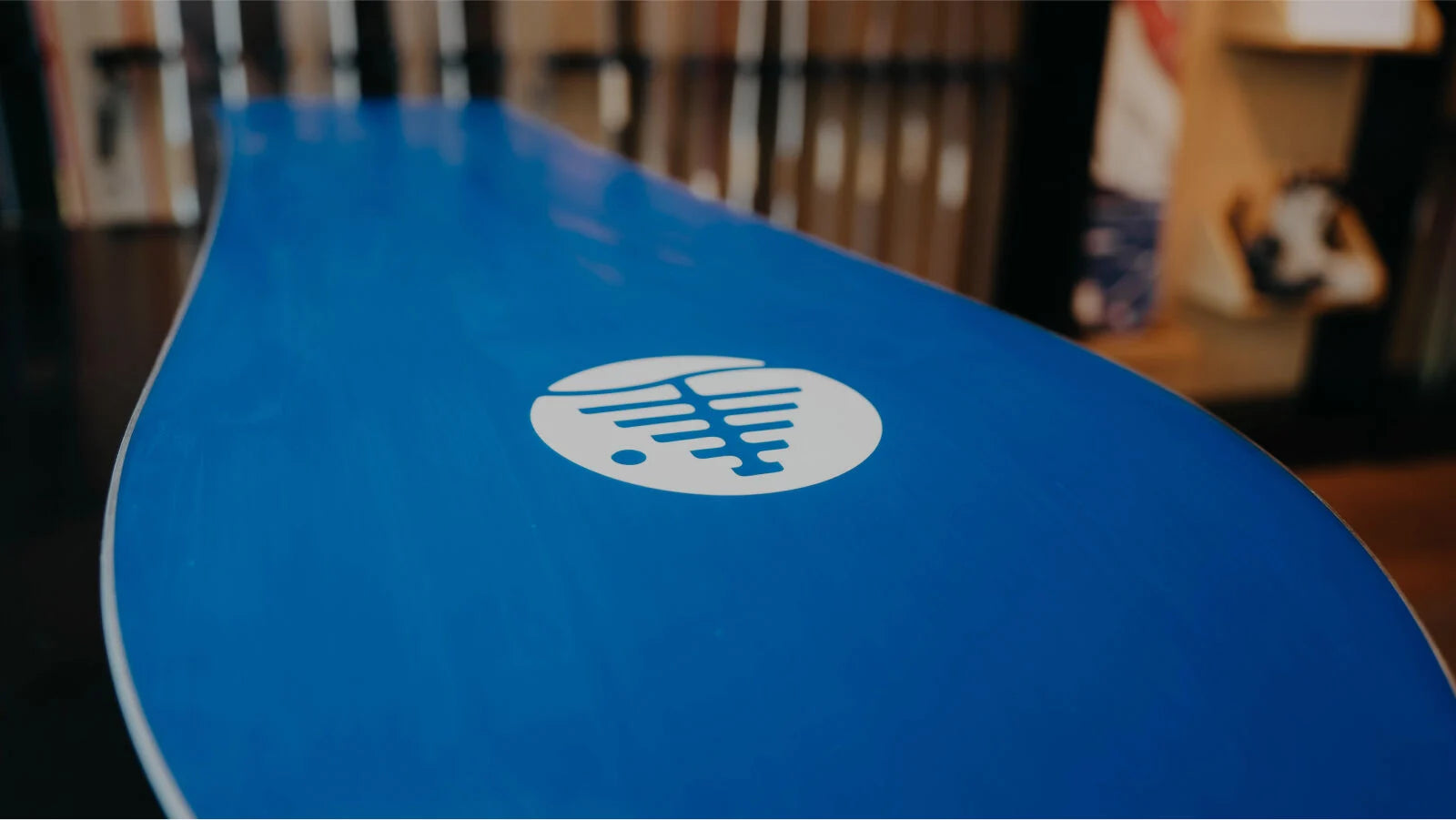 Bottom of a blue snowboard with the family tree logo