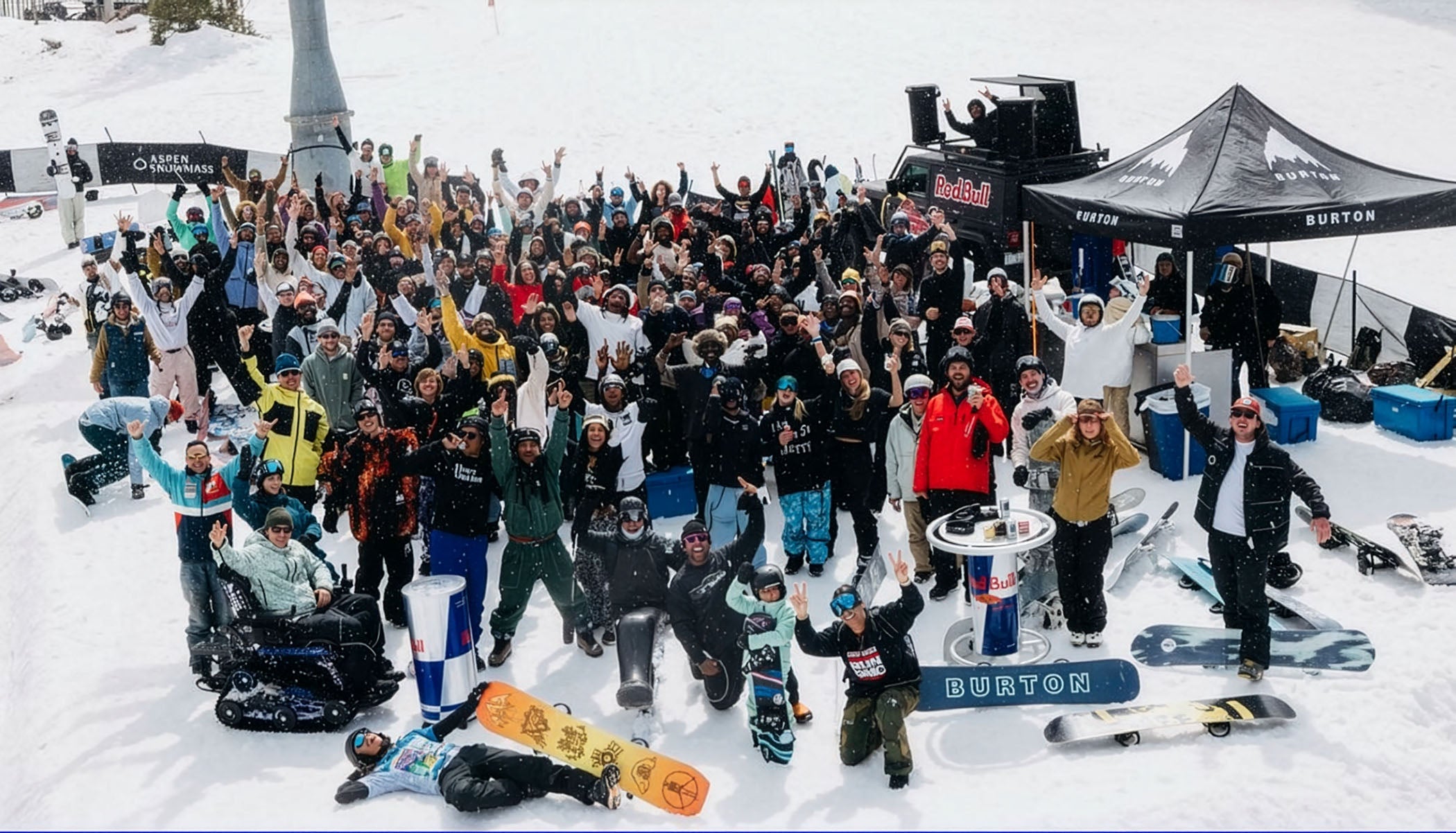 Large group of snowboarders gathered at the base for a photo