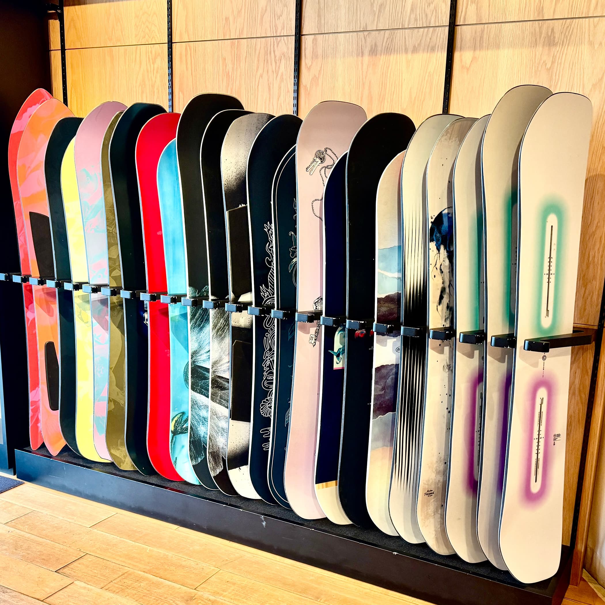Row of Burton certified used snowboards displayed on a rack