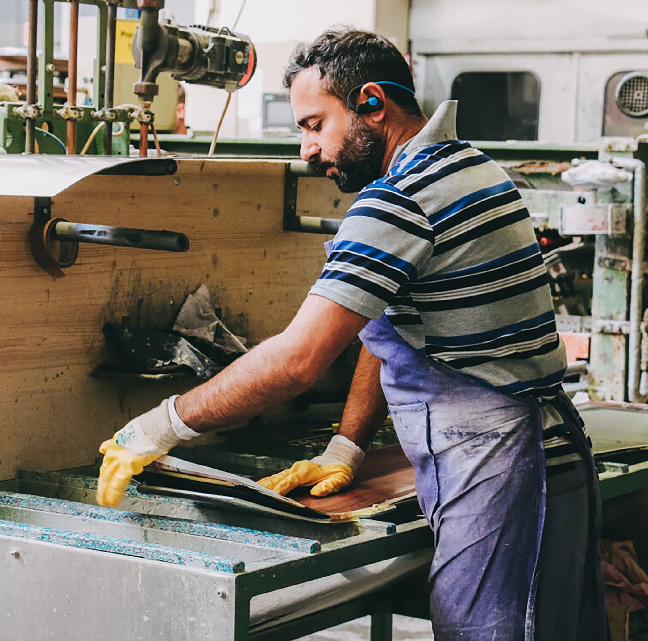 Factory worker assembling a snowboard topsheet 