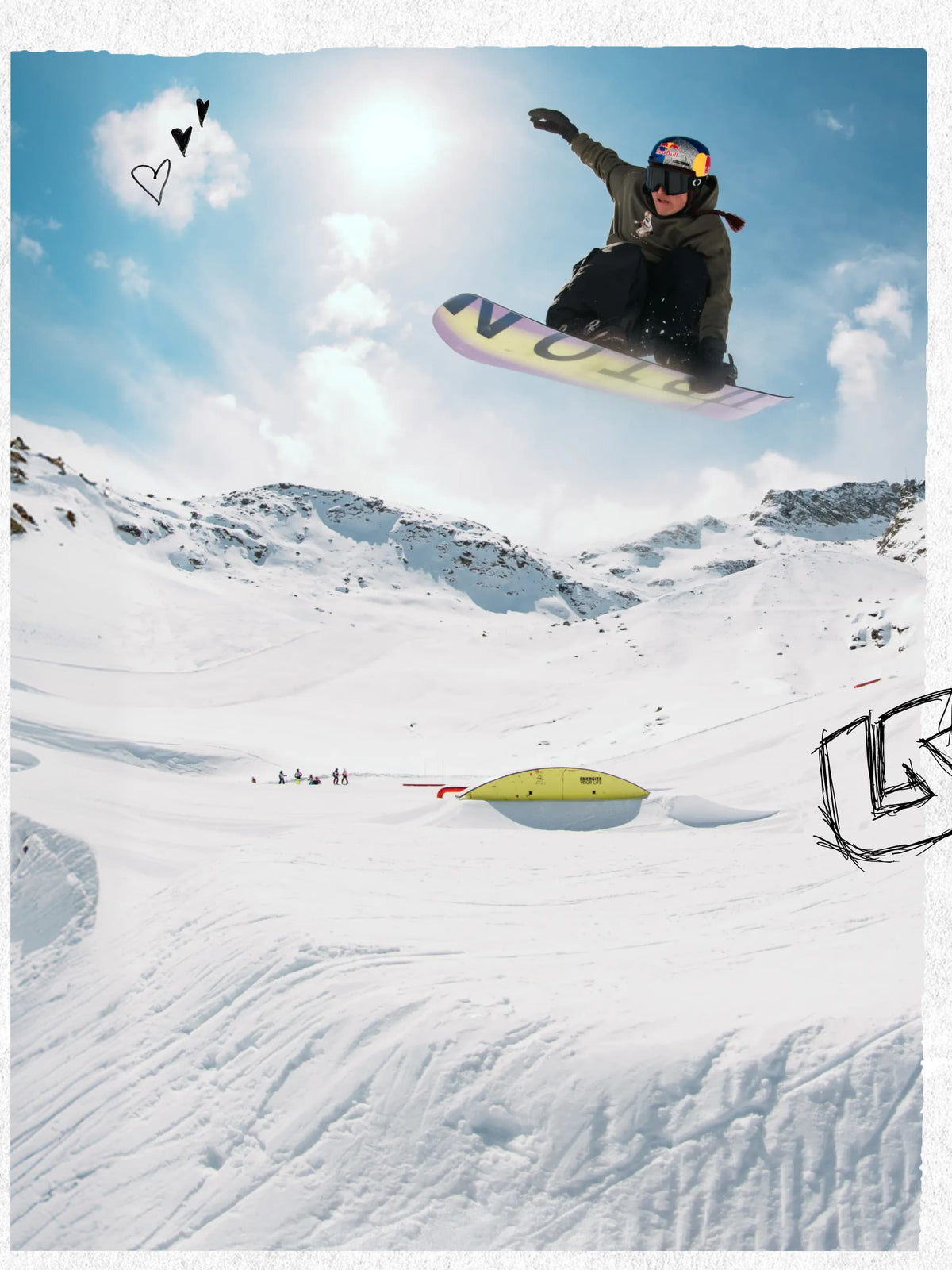 A snowboarder in mid-air performing a trick on a snowy mountain slope under a bright sun and blue sky, with a yellow snowboard visible and a yellow landing pad below.