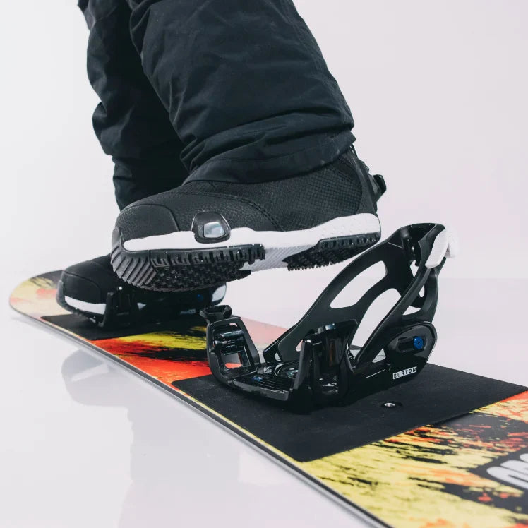 Close-up of a snowboard with a boot on a white background