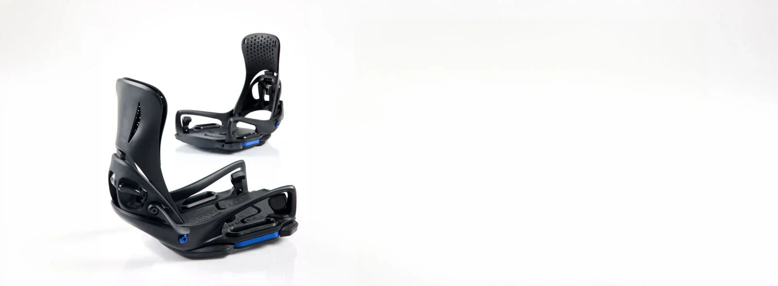 Black snowboard bindings on a white background