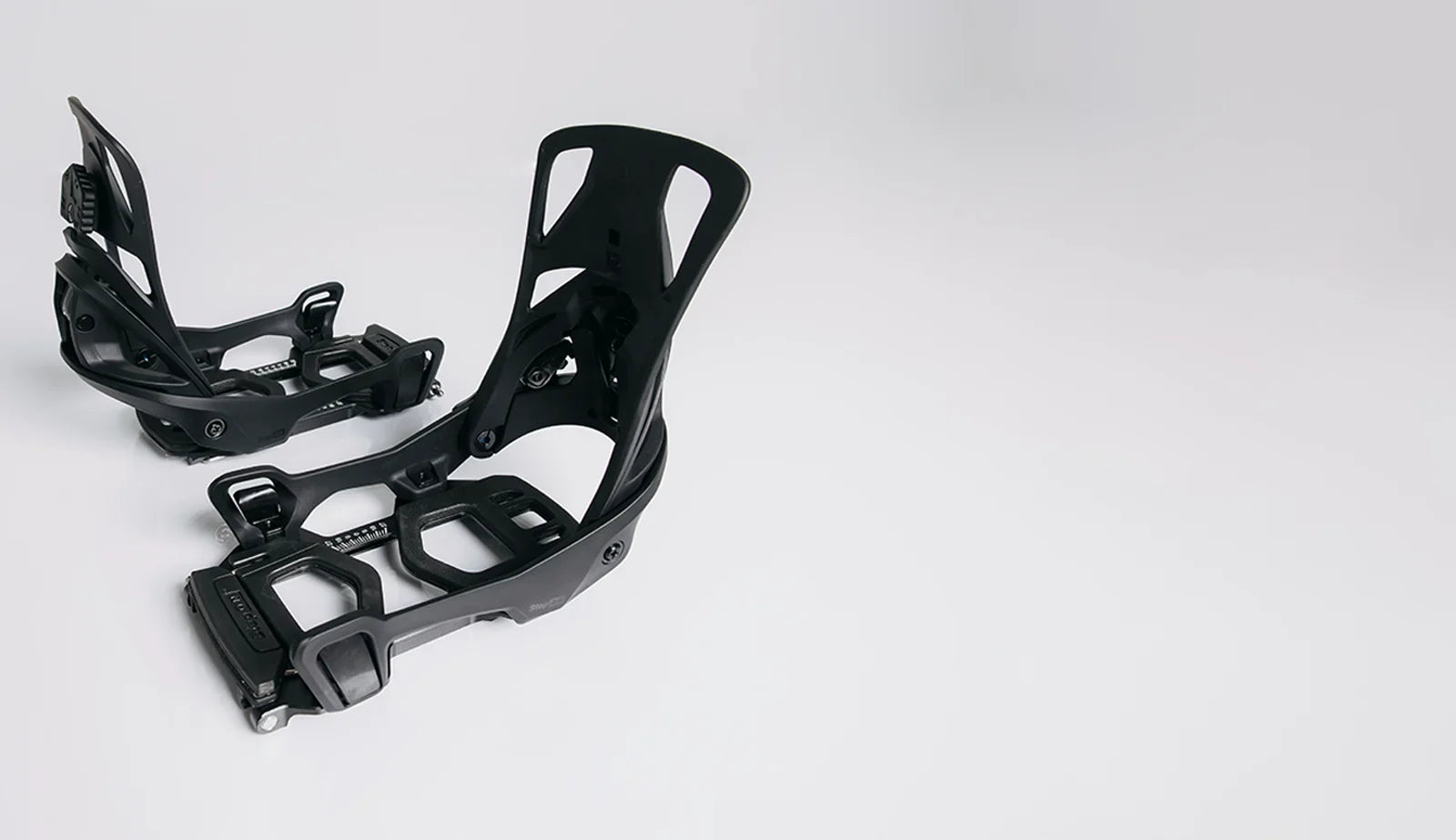 Black snowboard bindings on a white background