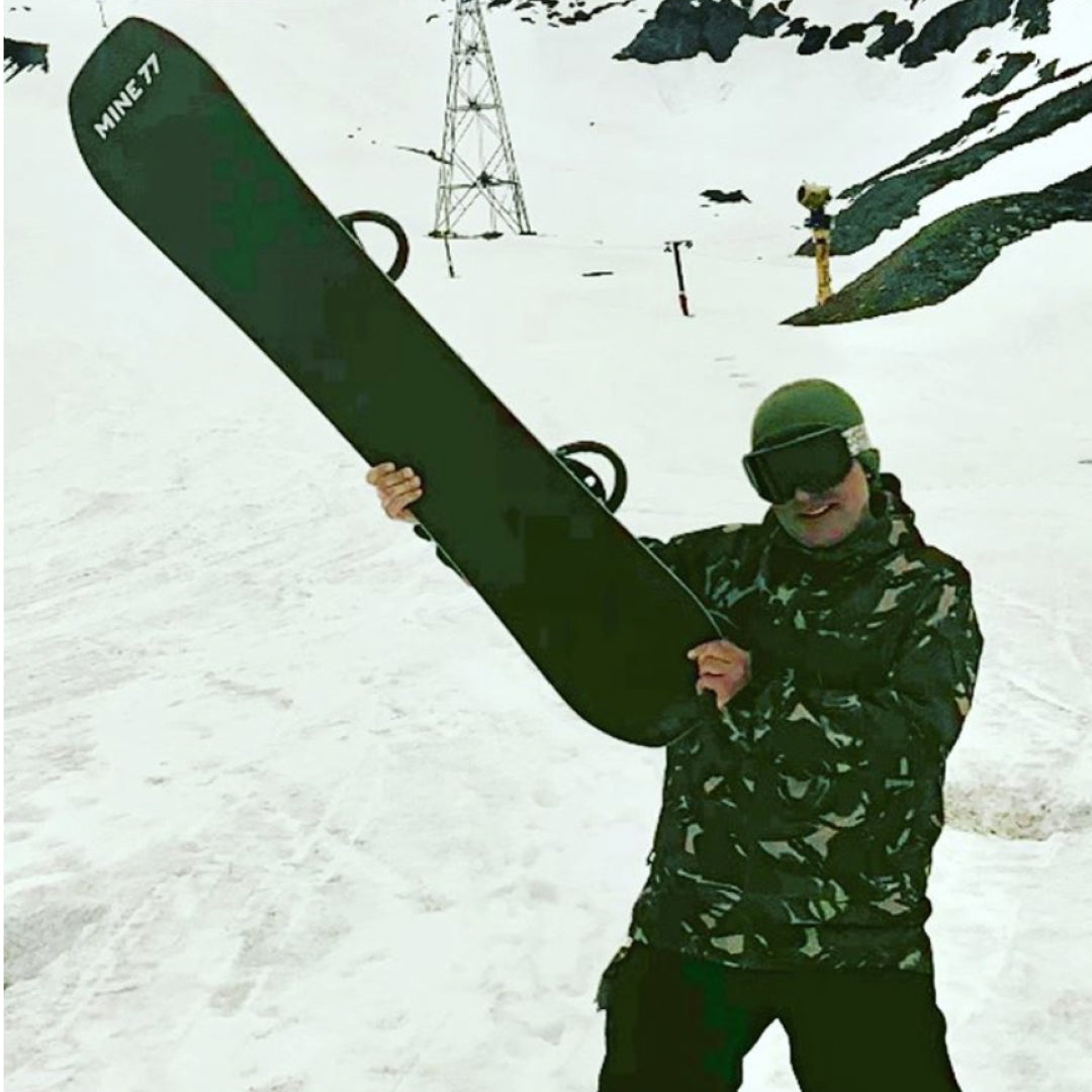 Jake poses on hill with a Mine77 snowboard