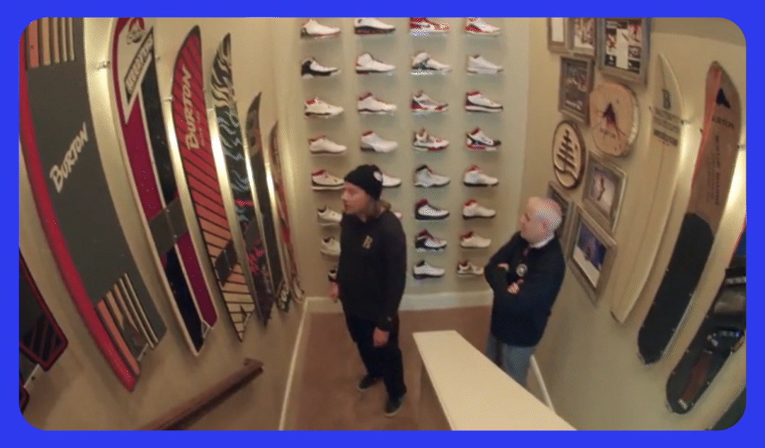 TK admiring a snowboard collector's snowboard collection in the stairwell of their home