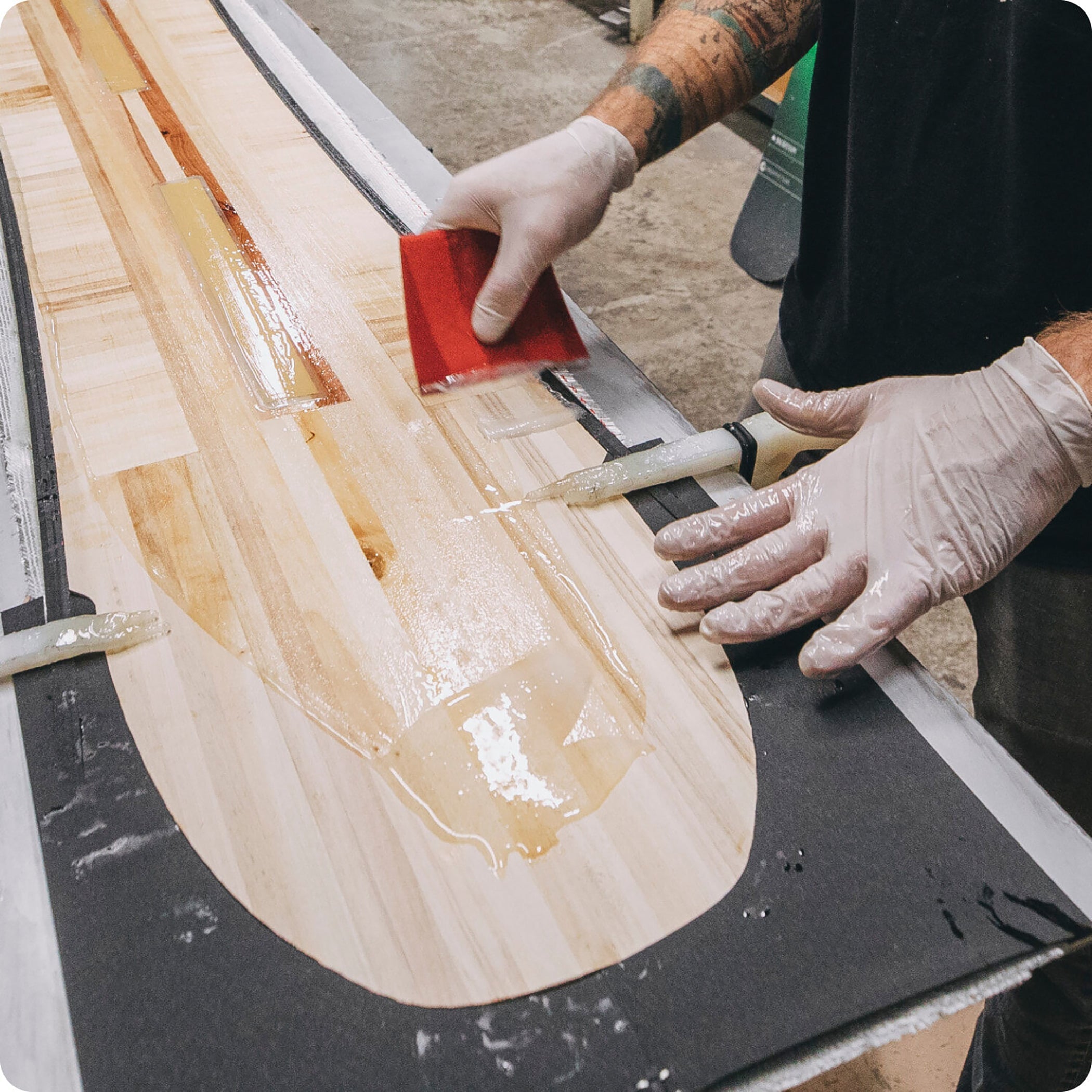 person applies bio-based epoxy to snowboard