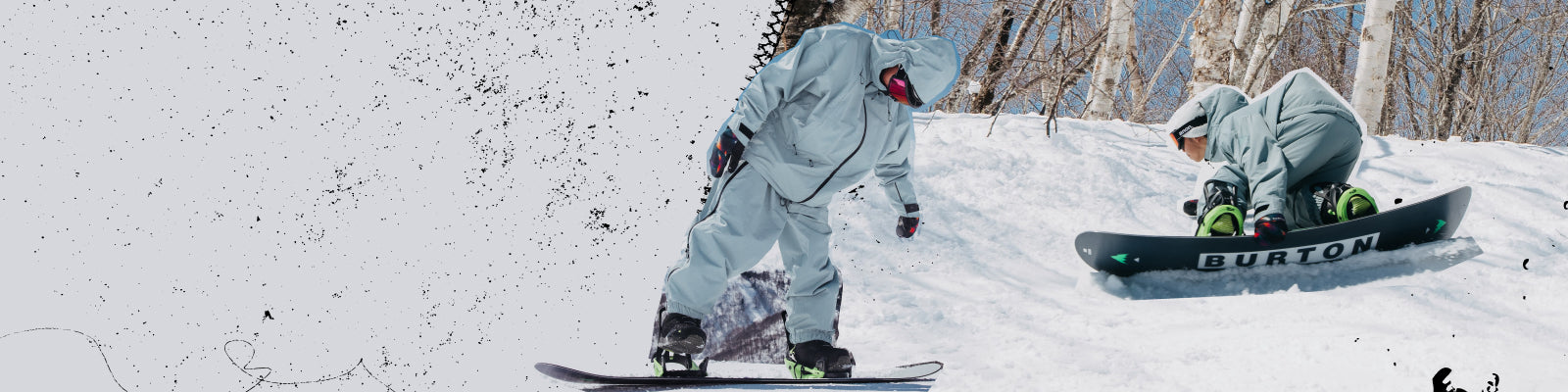 Two snowboarders in light gray snow suits on a snowy mountain slope, with one stepping on to their board and one and one riding.